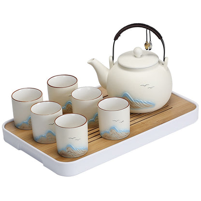 Matte distant-mountain tea set – bail-handle teapot and six cups in a frosted glaze with relief mountains