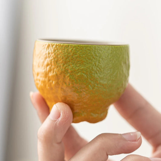 Green ombre tall citrus peel ceramic tea cup held in hand